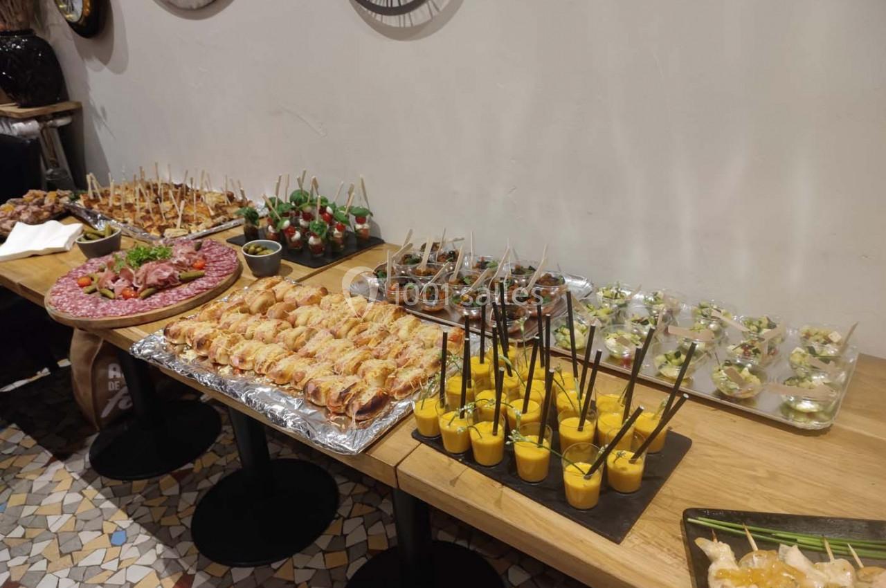 Buffet de verrines, brochettes et amuse-bouches variés disposés sur une table en bois.