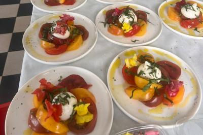 Assiette de légumes variés dressés avec soin, comprenant asperges, carottes, chou-fleur, roquette et sauce décorative.