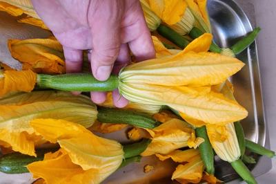 Assiette de légumes variés dressés avec soin, comprenant asperges, carottes, chou-fleur, roquette et sauce décorative.