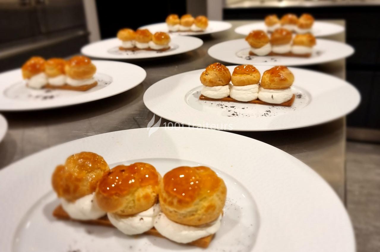 Assortiment de desserts individuels avec choux caramélisés, crème et base croustillante, présentés sur des assiettes…