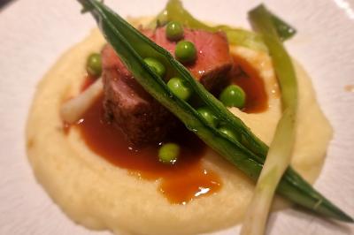 Assiette de légumes variés dressés avec soin, comprenant asperges, carottes, chou-fleur, roquette et sauce décorative.
