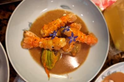 Assiette de légumes variés dressés avec soin, comprenant asperges, carottes, chou-fleur, roquette et sauce décorative.