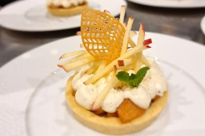 Assiette de légumes variés dressés avec soin, comprenant asperges, carottes, chou-fleur, roquette et sauce décorative.