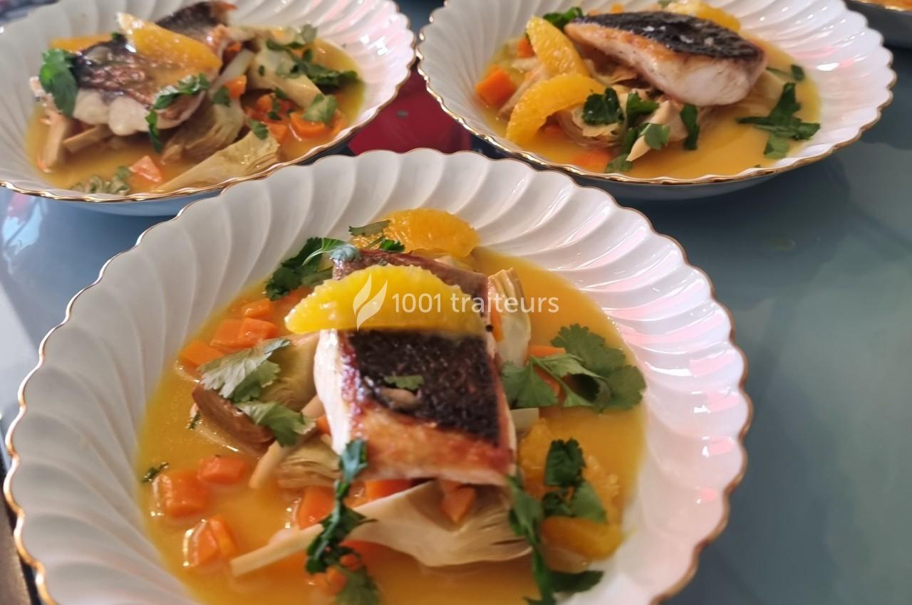 Filets de poisson grillés servis avec des légumes, des quartiers d'orange et une sauce, présentés dans des assiettes…