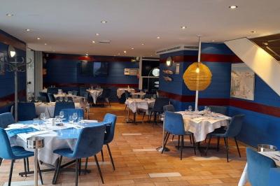 Des personnes se servent à un buffet en plein air, avec un chef en tenue blanche préparant des plats.