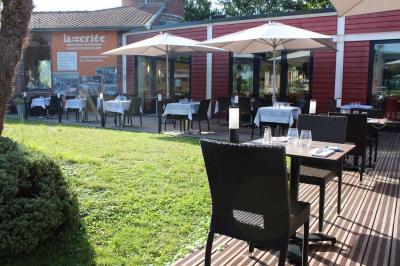 Des personnes se servent à un buffet en plein air, avec un chef en tenue blanche préparant des plats.