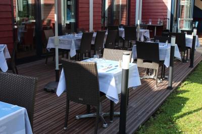 Des personnes se servent à un buffet en plein air, avec un chef en tenue blanche préparant des plats.