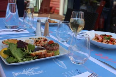 Des personnes se servent à un buffet en plein air, avec un chef en tenue blanche préparant des plats.