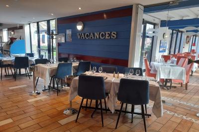 Dessert servi dans un verre avec mousse, crumble et zestes de citron, accompagné de deux verres de vin blanc sur une table…