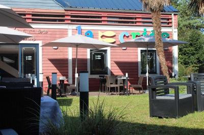 Dessert servi dans un verre avec mousse, crumble et zestes de citron, accompagné de deux verres de vin blanc sur une table…