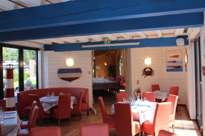 Dessert servi dans un verre avec mousse, crumble et zestes de citron, accompagné de deux verres de vin blanc sur une table…