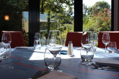 Dessert servi dans un verre avec mousse, crumble et zestes de citron, accompagné de deux verres de vin blanc sur une table…