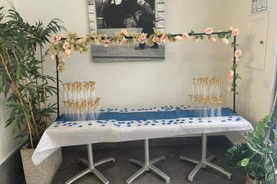 Terrasse ombragée avec des canisses, entourée de bâtiments et d'une structure bleue moderne en arrière-plan.