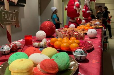 Miniature Buffet de Noël Deux personnes assises dans un buggy bleu en extérieur, discutant et manipulant des objets, avec un homme debout à côté.