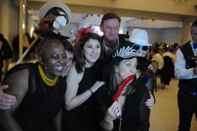 Miniature Soirée à thème Deux personnes assises dans un buggy bleu en extérieur, discutant et manipulant des objets, avec un homme debout à côté.