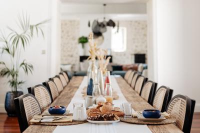 Baignoire blanche près d'une fenêtre, avec deux flacons de savon sur un tabouret en bois dans un espace lumineux.