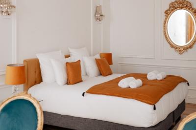 Vue d'une salle de bain avec une baignoire blanche, un tabouret en bois portant deux flacons, et une vitre donnant sur un…