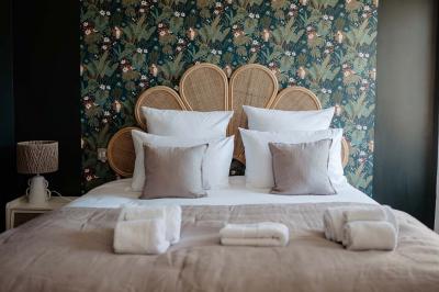Vue d'une salle de bain avec une baignoire blanche, un tabouret en bois portant deux flacons, et une vitre donnant sur un…