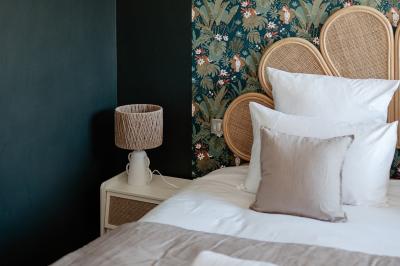 Vue d'une salle de bain avec une baignoire blanche, un tabouret en bois portant deux flacons, et une vitre donnant sur un…