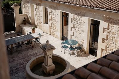 Vue d'une salle de bain avec une baignoire blanche, un tabouret en bois portant deux flacons, et une vitre donnant sur un…