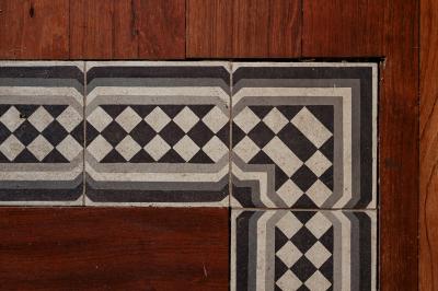 Vue d'une salle de bain avec une baignoire blanche, un tabouret en bois portant deux flacons, et une vitre donnant sur un…