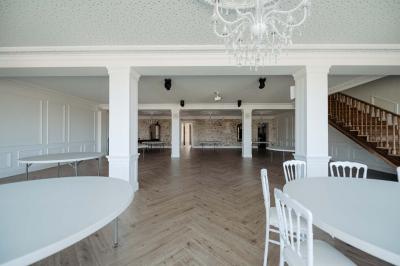 Vue d'une salle de bain avec une baignoire blanche, un tabouret en bois portant deux flacons, et une vitre donnant sur un…