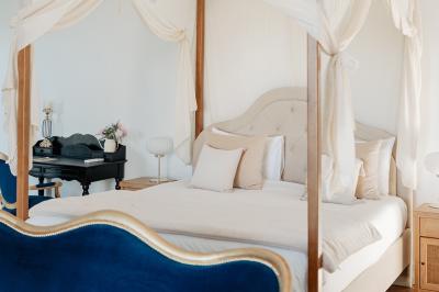 Vue d'une salle de bain avec une baignoire blanche, un tabouret en bois portant deux flacons, et une vitre donnant sur un…