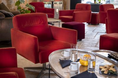 Statue en pierre représentant une femme tenant des épis de blé, placée au centre d'un bassin dans un jardin verdoyant.