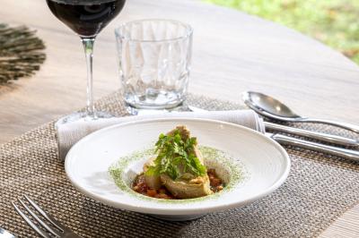 Statue en pierre représentant une femme tenant des épis de blé, placée au centre d'un bassin dans un jardin verdoyant.
