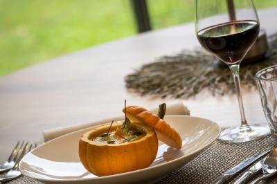 Statue en pierre représentant une femme tenant des épis de blé, placée au centre d'un bassin dans un jardin verdoyant.