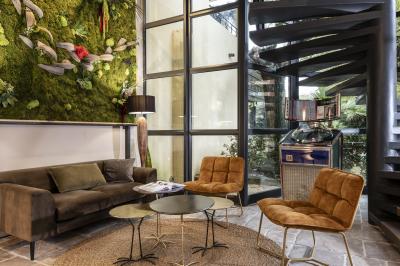 Statue en pierre représentant une femme tenant des épis de blé, placée au centre d'un bassin dans un jardin verdoyant.