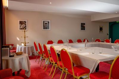 Statue en pierre représentant une femme tenant des épis de blé, placée au centre d'un bassin dans un jardin verdoyant.