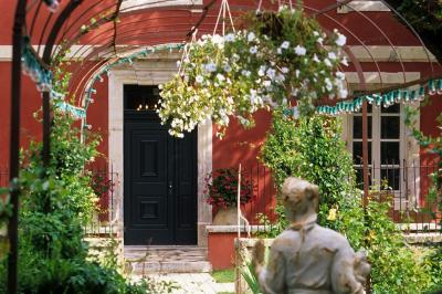 Statue en pierre représentant une femme tenant des épis de blé, placée au centre d'un bassin dans un jardin verdoyant.