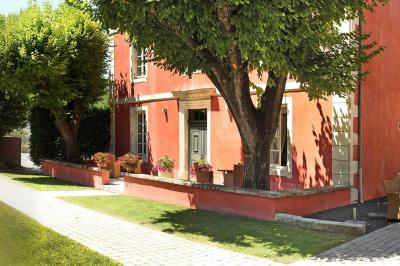 Statue en pierre représentant une femme tenant des épis de blé, placée au centre d'un bassin dans un jardin verdoyant.