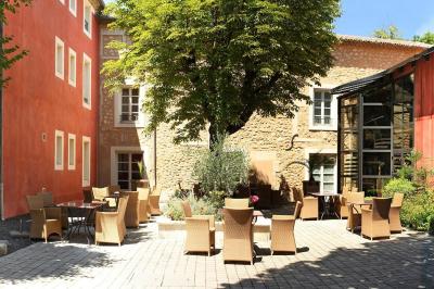 Statue en pierre représentant une femme tenant des épis de blé, placée au centre d'un bassin dans un jardin verdoyant.
