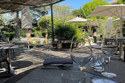 Statue en pierre représentant une femme tenant des épis de blé, placée au centre d'un bassin dans un jardin verdoyant.