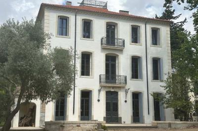 Chambre lumineuse avec deux lits simples, un bureau, une armoire en bois et une fenêtre donnant sur un jardin.