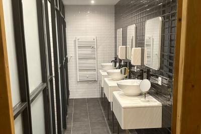 Chambre lumineuse avec deux lits simples, un bureau, une armoire en bois et une fenêtre donnant sur un jardin.