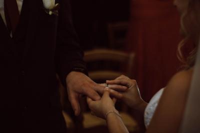 Salle décorée pour un événement avec des tables dressées en noir, rouge et blanc, et des chaises assorties.