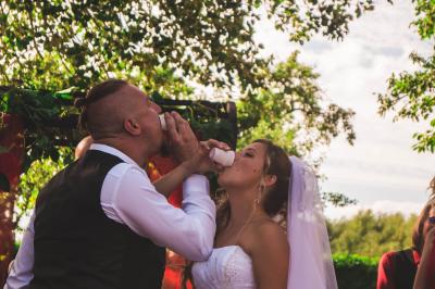 Salle décorée pour un événement avec des tables dressées en noir, rouge et blanc, et des chaises assorties.
