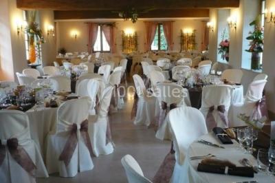 Miniature Location salle Saint-Aubin-sur-Gaillon (Eure) - Château de Beauchêne #3 Cheminée en pierre avec poutres en bois apparentes, ornée d'une composition florale dans une pièce lumineuse.