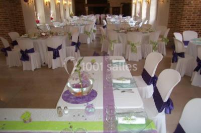 Miniature Location salle Saint-Aubin-sur-Gaillon (Eure) - Château de Beauchêne #5 Cheminée en pierre avec poutres en bois apparentes, ornée d'une composition florale dans une pièce lumineuse.