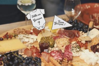 Plateaux de charcuterie et de fromages variés disposés sur une table avec des accompagnements en petits bols.