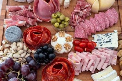 Plateaux de charcuterie et de fromages variés disposés sur une table avec des accompagnements en petits bols.