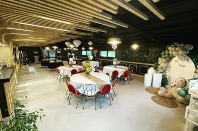 Centre de table avec une carafe d'eau, un vase contenant une bougie flottante, des fleurs blanches et un numéro 3 en bois.