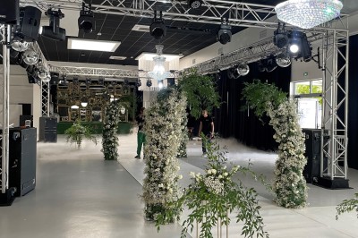 Miniature Location salle Artigues-près-Bordeaux (Gironde) - Espace Descartes Réceptions #31 Bar mobile blanc décoré de fleurs et de verres suspendus, installé en extérieur sous une tente près d'un espace arboré.