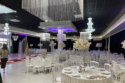 Miniature Location salle Artigues-près-Bordeaux (Gironde) - Espace Descartes Réceptions #3 Bar mobile blanc décoré de fleurs et de verres suspendus, installé en extérieur sous une tente près d'un espace arboré.