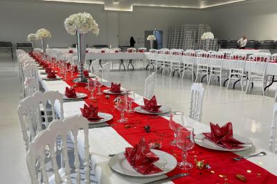 Deux roll-ups promotionnels et une table noire avec des boîtes en bois dans une salle lumineuse au sol blanc.