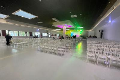 Deux roll-ups promotionnels et une table noire avec des boîtes en bois dans une salle lumineuse au sol blanc.