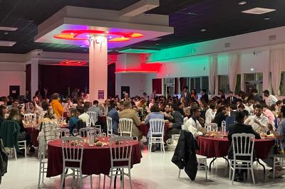 Deux roll-ups promotionnels et une table noire avec des boîtes en bois dans une salle lumineuse au sol blanc.